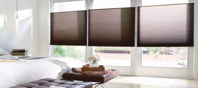 Modern Miami bedroom with high windows and brown honeycomb shades.