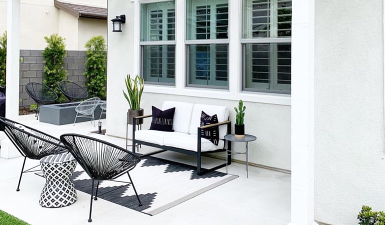 Spending a few hours mulching and weeding can help give you an outdoor oasis. Backyard with plantation window treatments