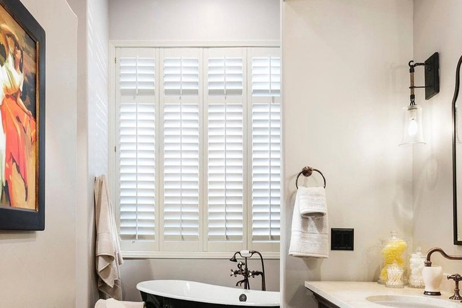 Wide white Polywood shutters inside a bathroom.