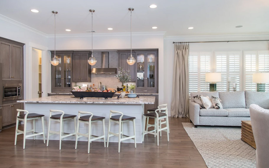 Illuminate your home with custom interior shutters in Miami. White arched shutters in a white kitchen with lots of light.