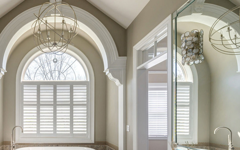 White arched shutters in a fancy bathroom.