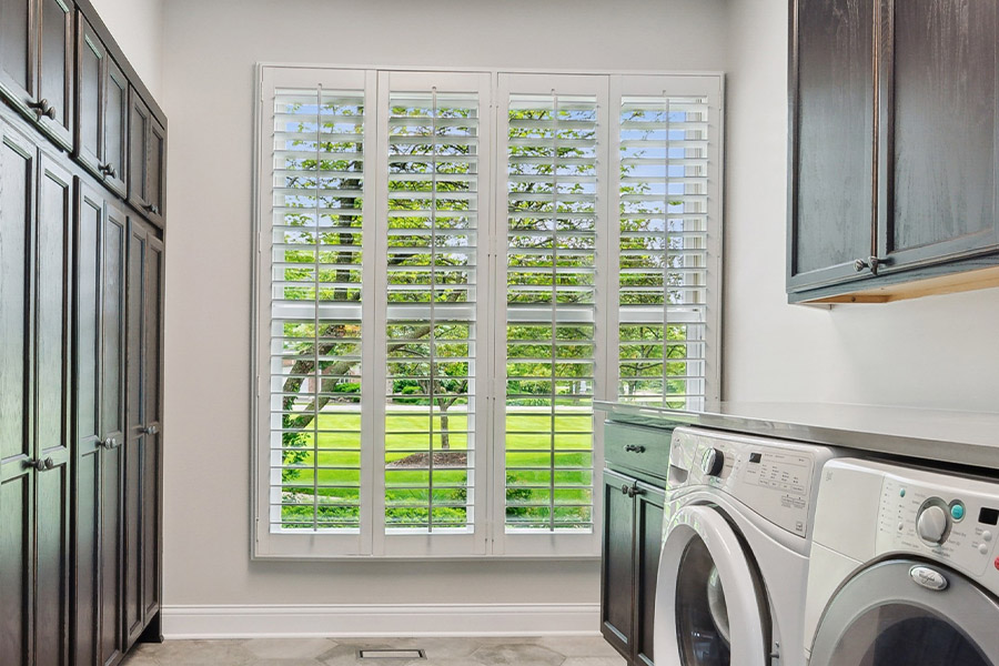 Find the perfect level of natural light for your Miami laundry room with interior shutters. White Polywood shutters letting light through a laundry room window