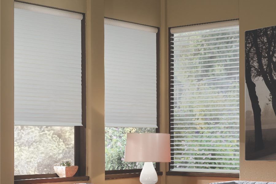 Opaque motorized window shades in Miami keep hot UV rays out of your home. Gray motorized sheer shades on corner windows next to gray furniture