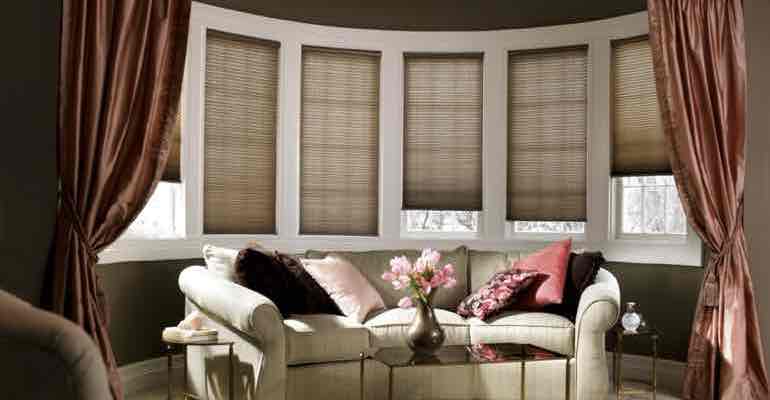 Adjustable cellular shades in lounge bow window.