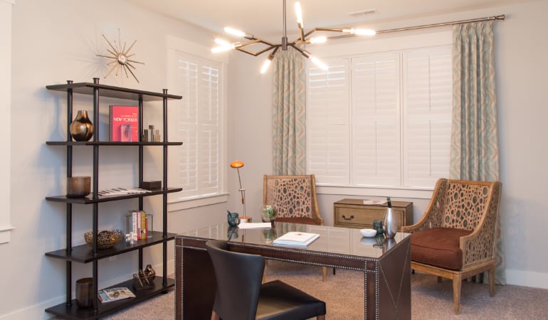 Picking the right window treatments can result in an increase in natural light. Miami home office with plantation shutters.