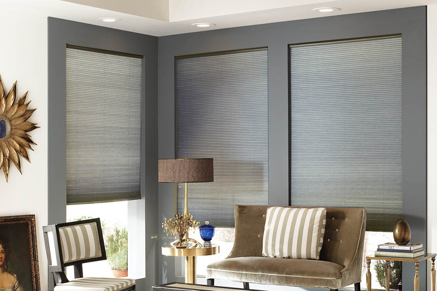 Add style and comfort to your home with cellular shades in Miami. Gray cellular shades in a corner of a stylish living room.