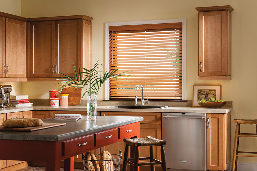 Waterproof faux wood blinds are durable and give you privacy and light control in your Miami kitchen. Dark faux wood blinds above a kitchen sink