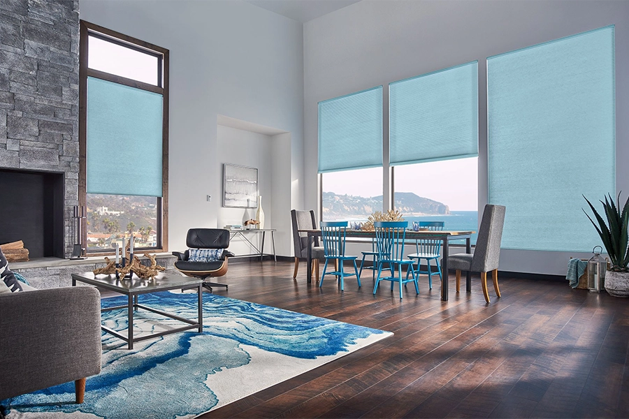 Smart motorized window shades are perfect on tall windows in your Miami home. Blue motorized shades on tall living room windows